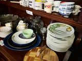 a lot of plates and bowls on a wooden shelf