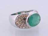 a close up of a ring with a green stone on it