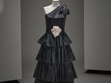 une robe noire posée sur un présentoir à mannequin dans une pièce
