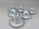 six cups and saucers sitting on a white table