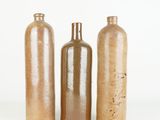 three brown glass bottles sitting next to each other on a white surface