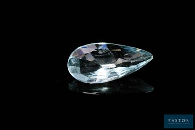 un gros plan d'un diamant transparent posé sur une surface noire