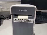 une petite imprimante posée sur un bureau, à côté d'un ordinateur