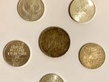 six different coins are arranged in a circle on a white surface
