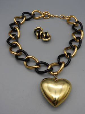 Collier gourmette en métal noir et doré retannant un gros cœ…