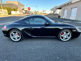 une photo d'une Porsche noire garée sur un parking