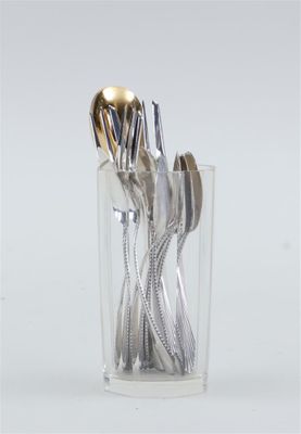 silverware in a clear glass with a gold spoon and fork in it