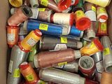 many spools of thread in a box on the floor