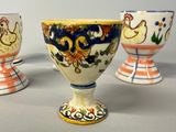 three egg cups with designs on them sitting on a table