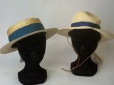 deux chapeaux posés sur une tête de mannequin ornée d'un ruban bleu