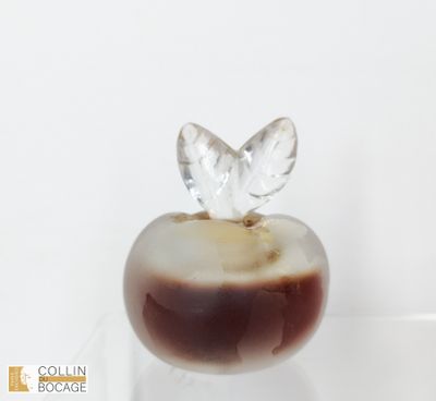 une pomme en verre surmontée d'une feuille en cristal