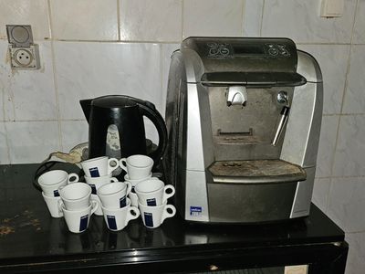 a coffee maker and cups on a counter in a kitchen