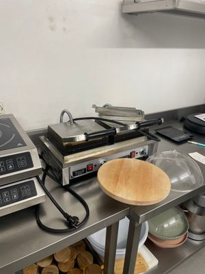 plan de travail en acier inoxydable avec une plaque de cuisson et un four intégré à la plaque de cuisson