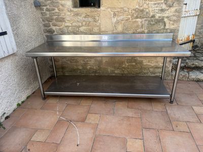a stainless steel table on the ground outside