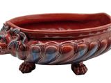 a red and blue planter with a lion head on it