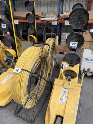 several yellow hoses are stacked on top of each other in a warehouse