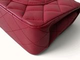 a close up of a red purse on a white surface