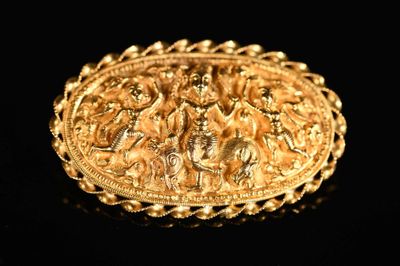 une image représentant une broche en or sur laquelle figure une scène mettant en scène un homme et une femme