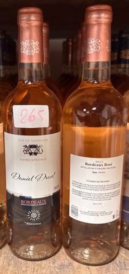 plusieurs bouteilles de vin sont alignées sur une étagère