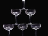 six verres à vin transparents sont empilés les uns sur les autres