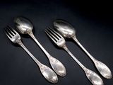three silver spoons and a fork on a black surface
