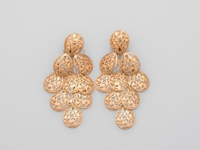 une paire de boucles d'oreilles en or sur fond blanc