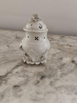 un petit vase blanc posé sur une table en marbre