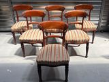 six chaises anciennes aux assises rembourrées à rayures dans une pièce