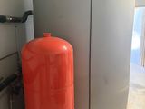 an orange tank next to a white container on the floor