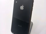 a black iphone sitting on a stand on a white surface