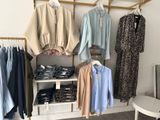 many shirts hanging on a rack in a clothing store