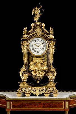 a gold clock sitting on top of a marble table