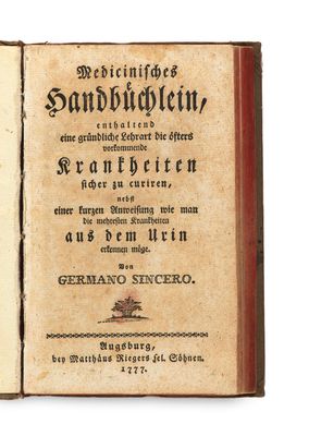 an old book with writing on it sitting on top of a white surface