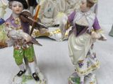 two figurines of people standing next to each other