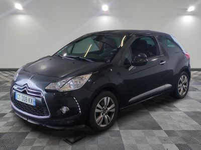 La Citroën noire est garée dans le garage, sur un sol à damier.