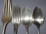 four spoons and a fork on a table