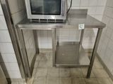 a microwave sitting on top of a stainless steel table