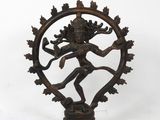 une statue en bronze du dieu hindou Shiva dans un cadre circulaire