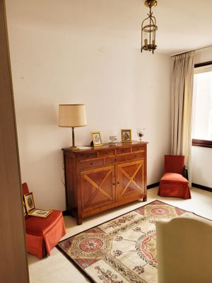 un salon avec un canapé, un fauteuil, une table et une fenêtre