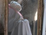 a white dress on a mannequin in front of a mirror
