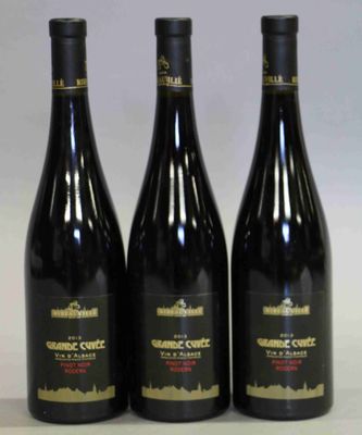 trois bouteilles de vin posées sur une table l'une à côté de l'autre