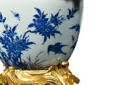 a blue and white bowl with gold accents on a stand