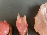 two pieces of pink quartz sitting on top of a table next to a rock
