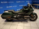 a green motorcycle parked in front of a blue wall