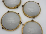 un ensemble de quatre appliques murales en laiton plaqué, dotées d'abat-jours en verre dépoli