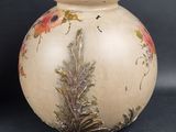 a white vase with a floral design on it