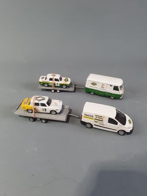 four toy cars and a truck on a gray surface