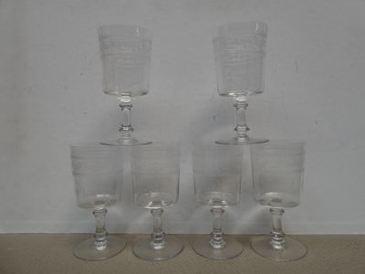 three clear wine glasses sitting on top of each other on a table