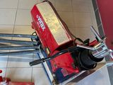 a small red machine that is sitting on the floor