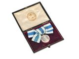 an image of a medal in a box with a ribbon around it